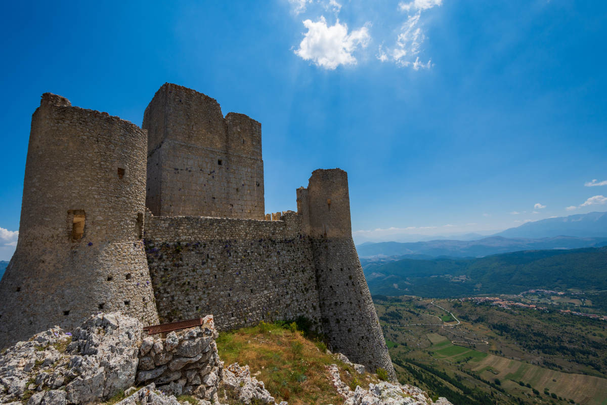 @ Rocca Calascio, en middelaldersk steinborg som ruver over Abruzzos fjellandskap, med utsikt over daler og fjell så langt øyet rekker.