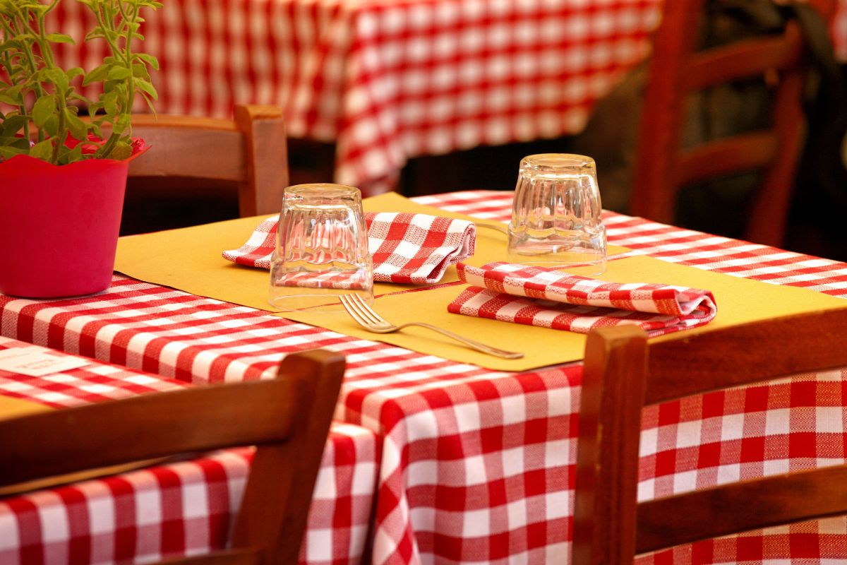 Italiensk restaurantbord med rutete duk og enkel oppdekning – klar for en ekte matopplevelse
