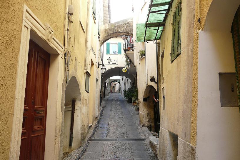 Smalt historisk smug i Castellaroi Liguria, med pastellfargete hus og middelaldersk atmosfære