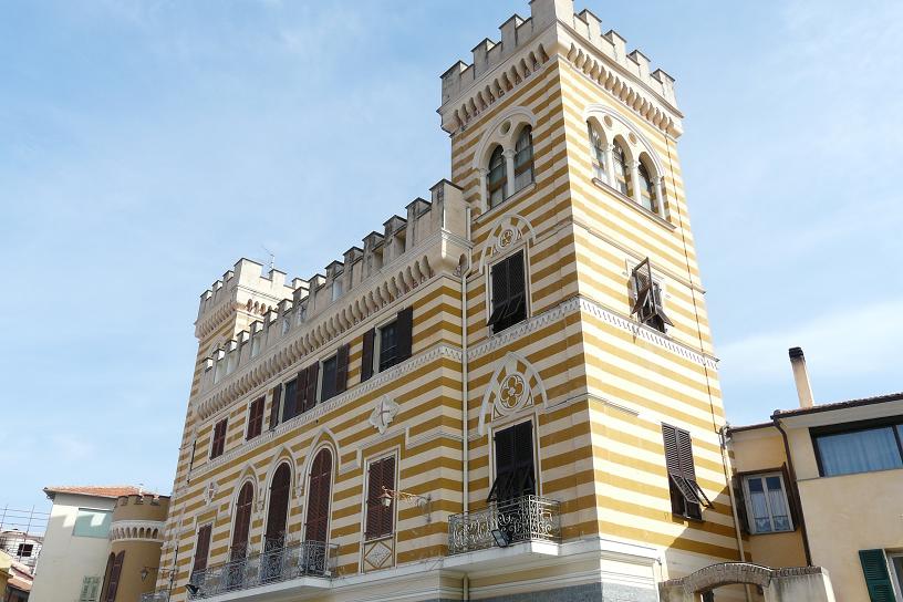 Castello Arnaldi i Castellaro, et nygotisk herskapshus fra 1800-tallet omgitt av grønt landskap i Liguria
