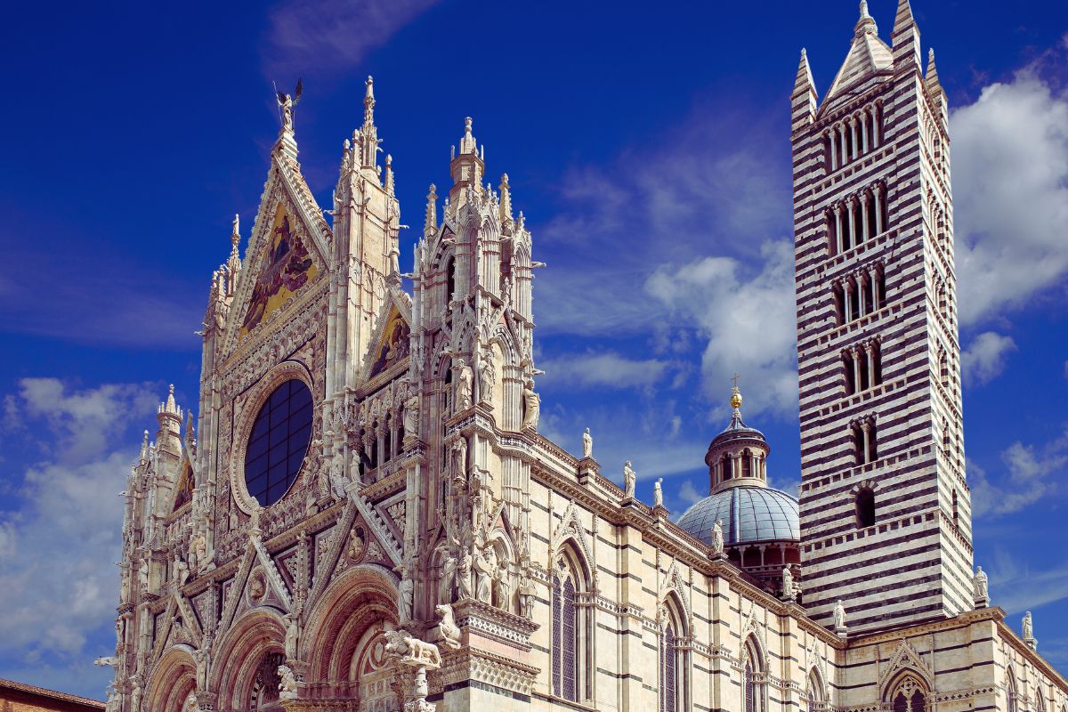Fasaden til katedralen i Siena, med hvit og grønn lokal stein i gotisk stil.