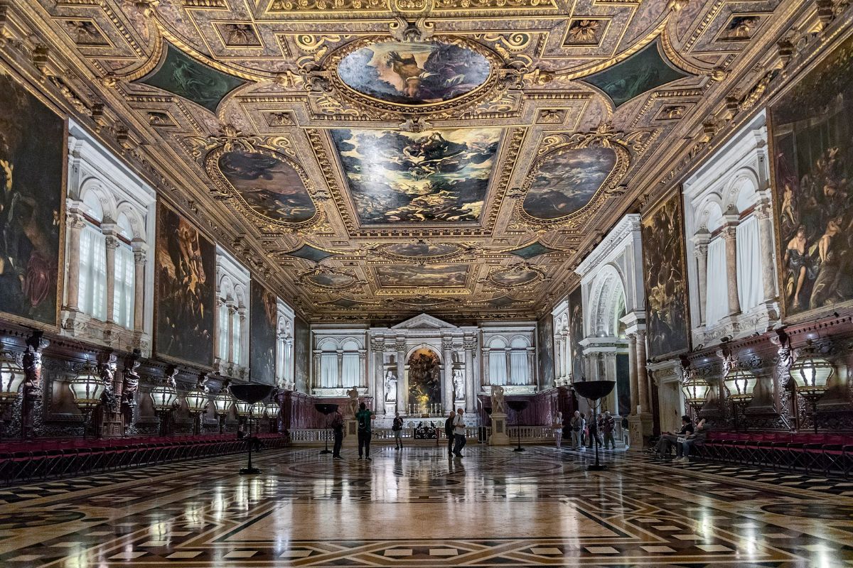 Kapitelsalen i Scuola Grande di San Rocco i Venezia, med utskårne tresøyler, forgylte detaljer og Tintorettos malerier i taket.