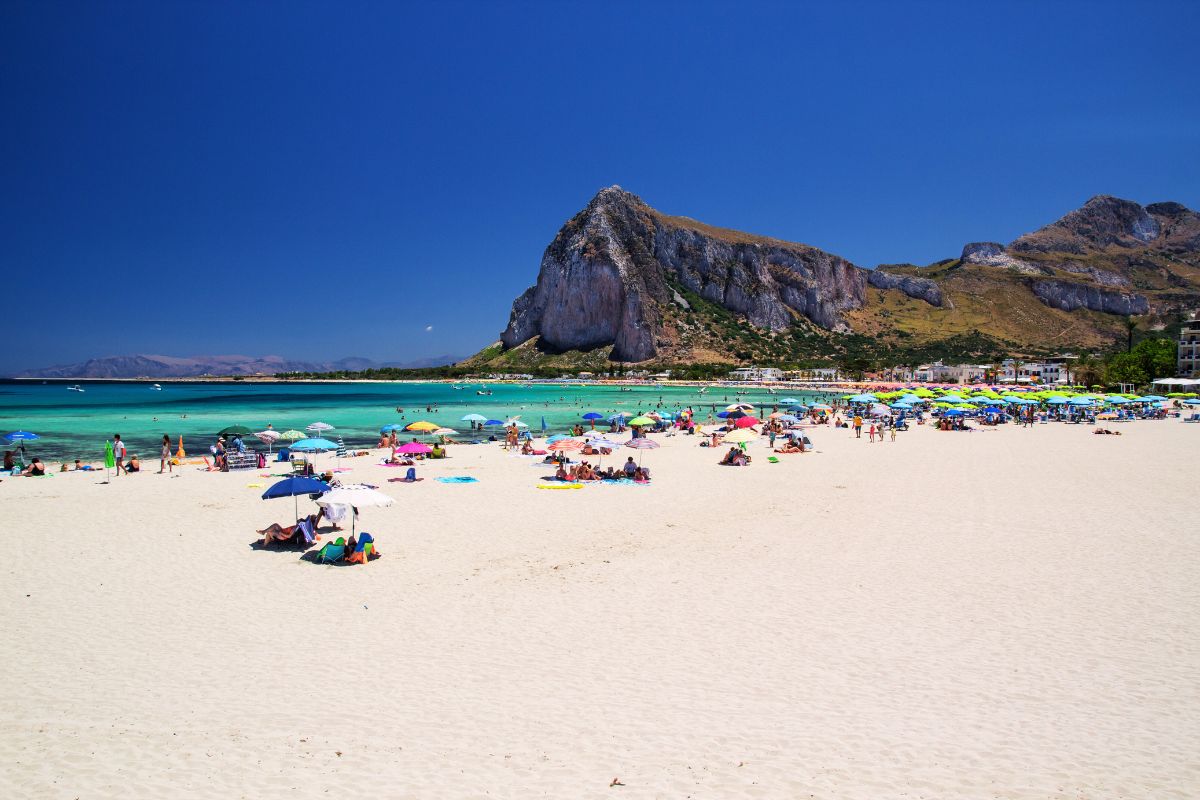 Stranden i San Vito Lo Capo – hvit sand, turkis vann og fjell i bakgrunnen gjør dette til en av de vakreste badeplassene på Sicilia.