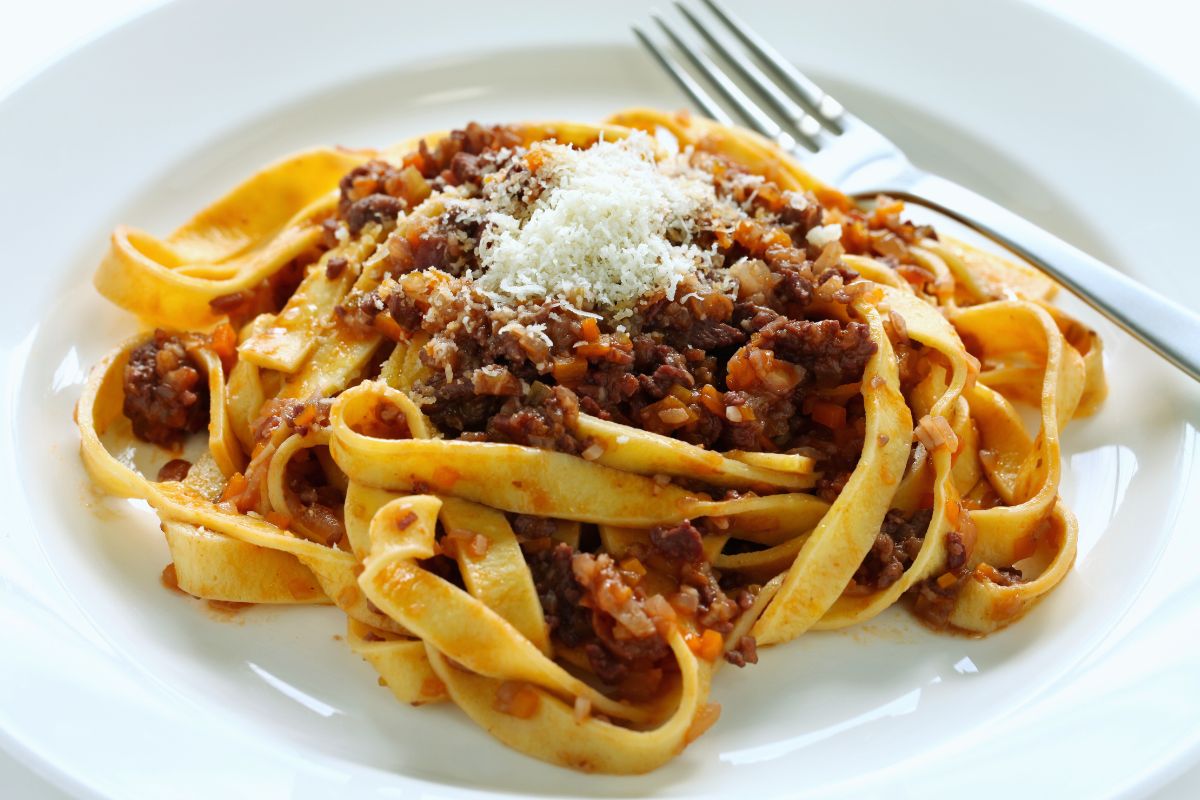 Tagliatelle bolognese med Parmigiano. Tagliatelle alla bolognese med revet Parmigiano Reggiano – ekte italiensk pastarett med kjøttsaus og ost