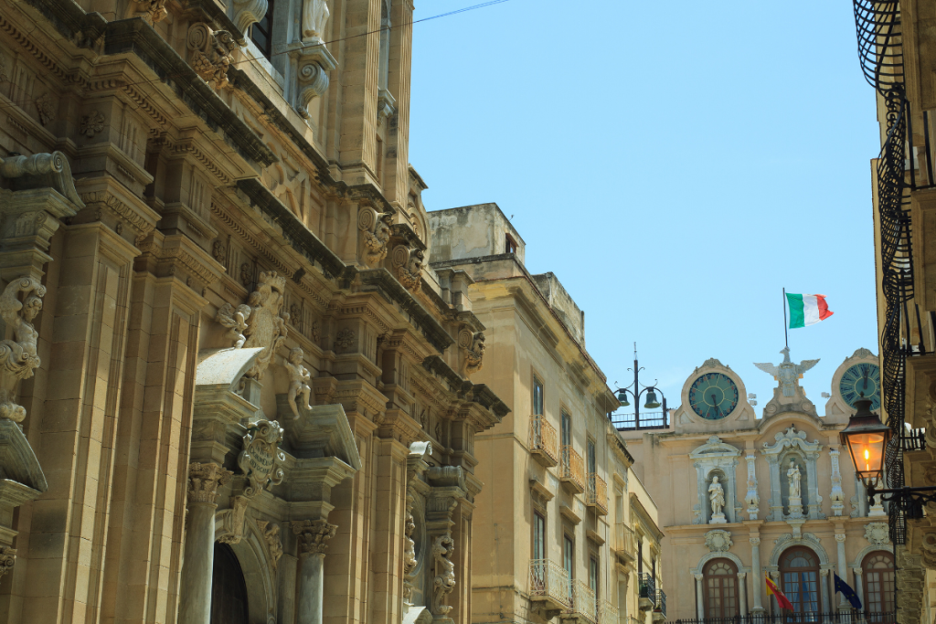 Utsikt over en gate i gamlebyen i Trapani, Sicilia, med barokke bygninger og middelhavsstemning.