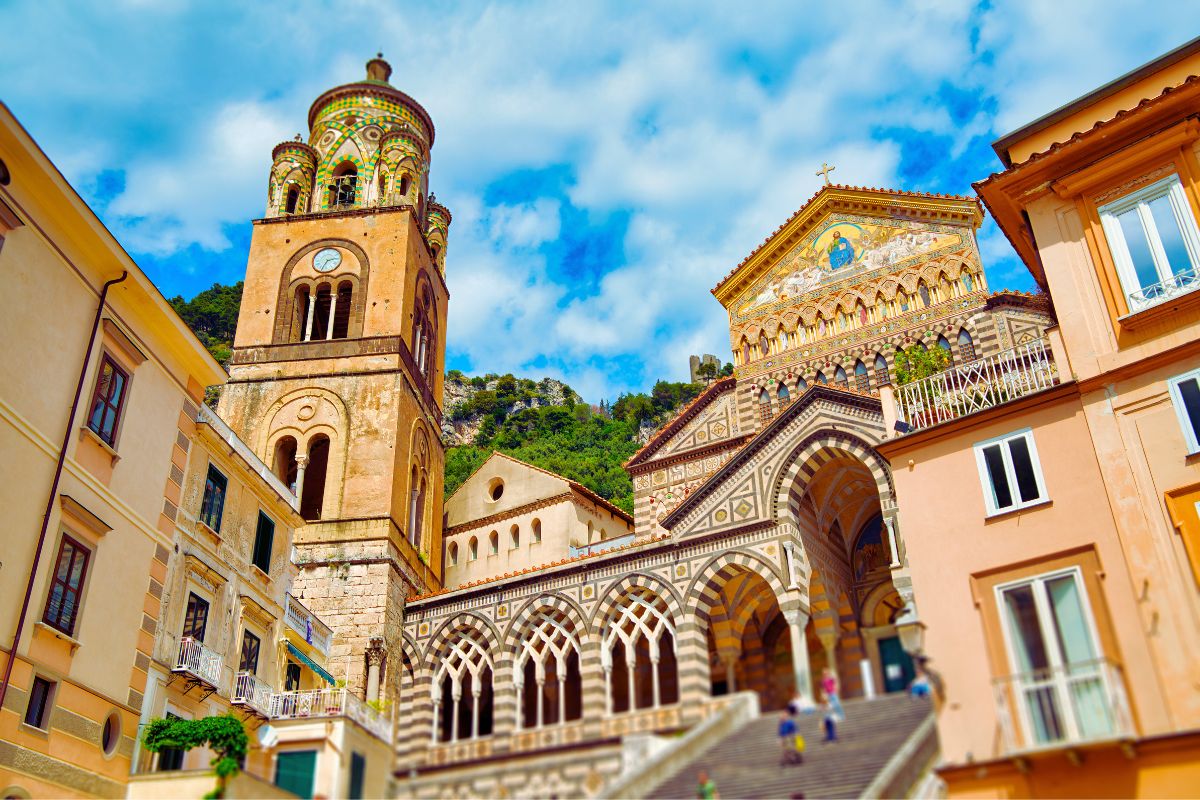 Domkirken i Amalfi med trappene og det fargerike fasadetårnet sett fra piazzaen