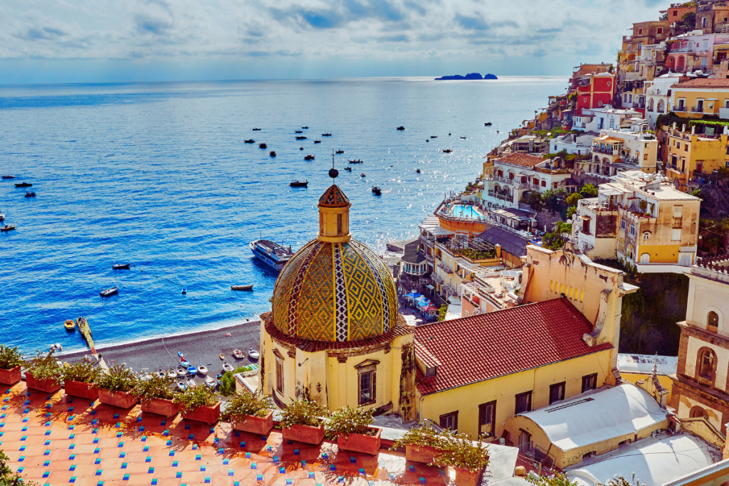 Utsikt over Positano med kirken Santa Maria Assunta og havet i bakgrunnen.