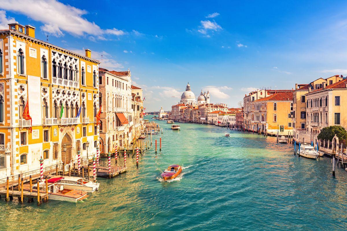Canal Grande i Venezia Utsikt over Canal Grande i Venezia med fargerike bygninger og Santa Maria della Salute i bakgrunnen.