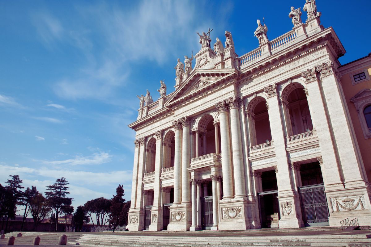 Fasaden til San Giovanni in Laterano i Roma, bygget på 1700-tallet av Alessandro Galilei, med kolonner og monumentale statuer på toppen.