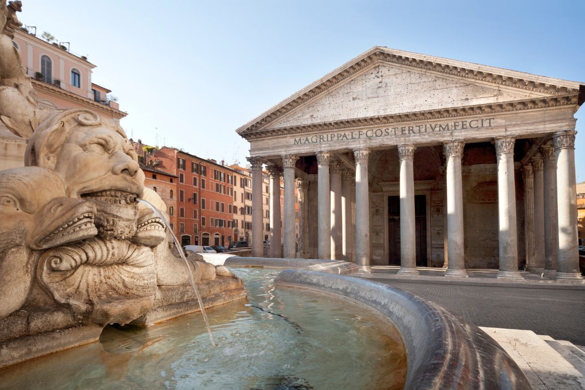 Pantheon i Roma med fontenen i forgrunnen, badet i morgensol og omgitt av historiske bygninger.