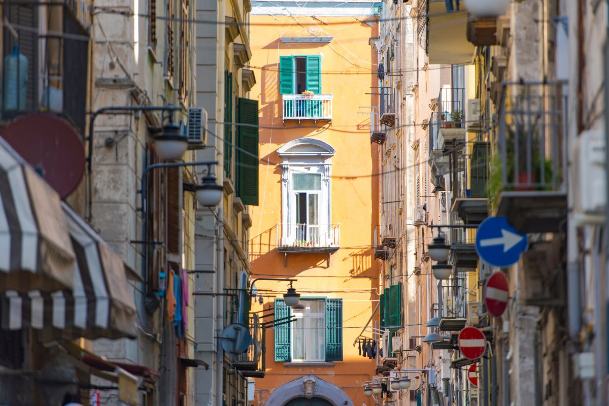 Gate i Quartieri Spagnoli i Napoli med fargerike fasader, balkonger og grønnmalte skodder – et ekte glimt av byens atmosfære.