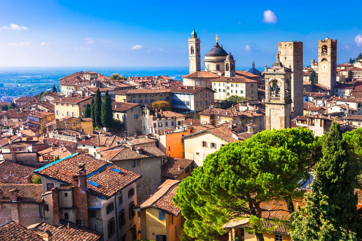 Utsikt over Bergamo Alta med historiske bygninger, tårn og tak i sollys, Lombardia, Italia.