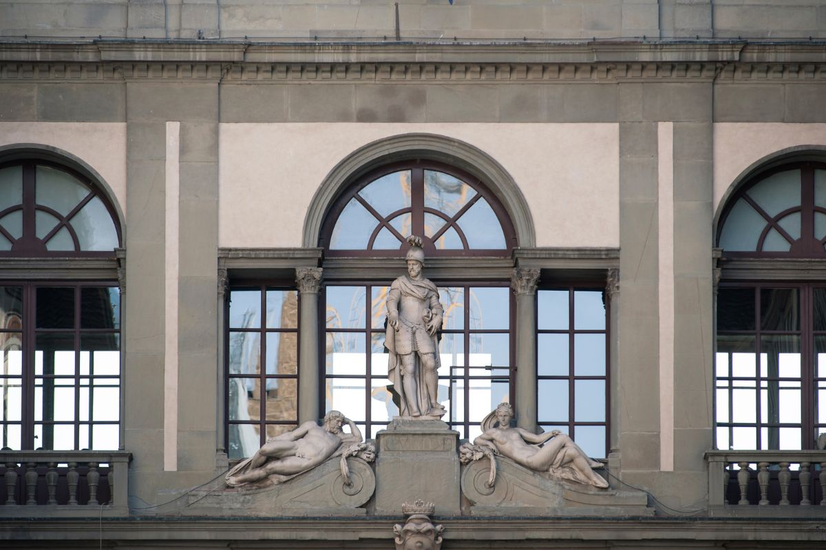 Fasaden til Uffizi-galleriet i Firenze med statue og klassiske arkitektoniske detaljer.