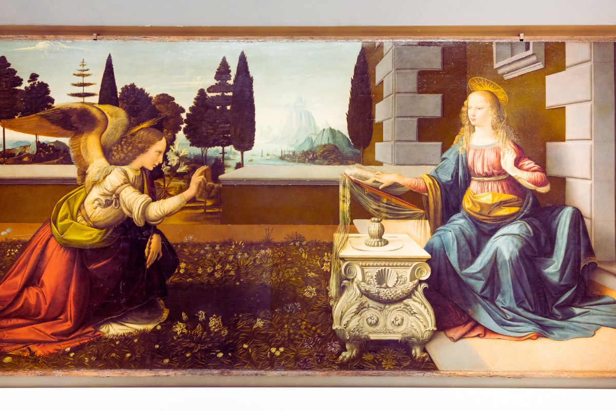 Maleriet «Bebudelsen» av Leonardo da Vinci, med engelen Gabriel og Maria i et rolig renessanselandskap, utstilt i Uffizi-galleriet i Firenze.