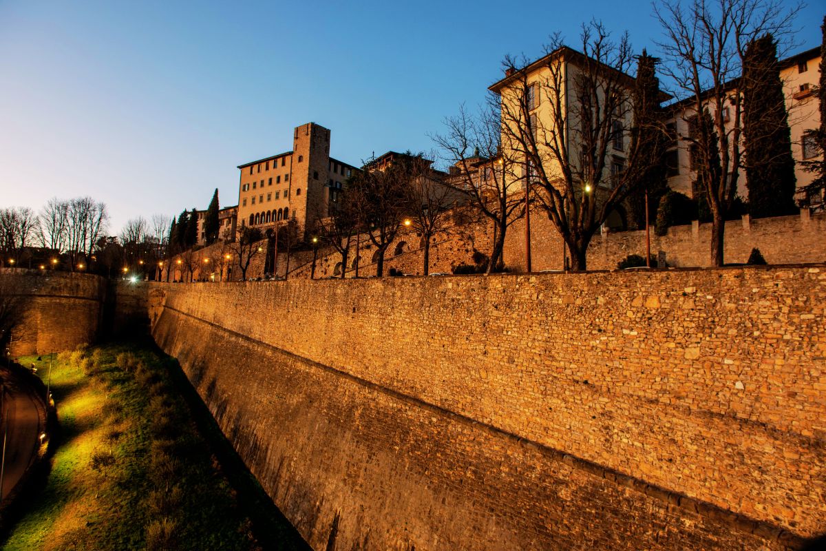 Mura Veneziane i Bergamo, opplyste bymurer rundt Città Alta ved skumring.