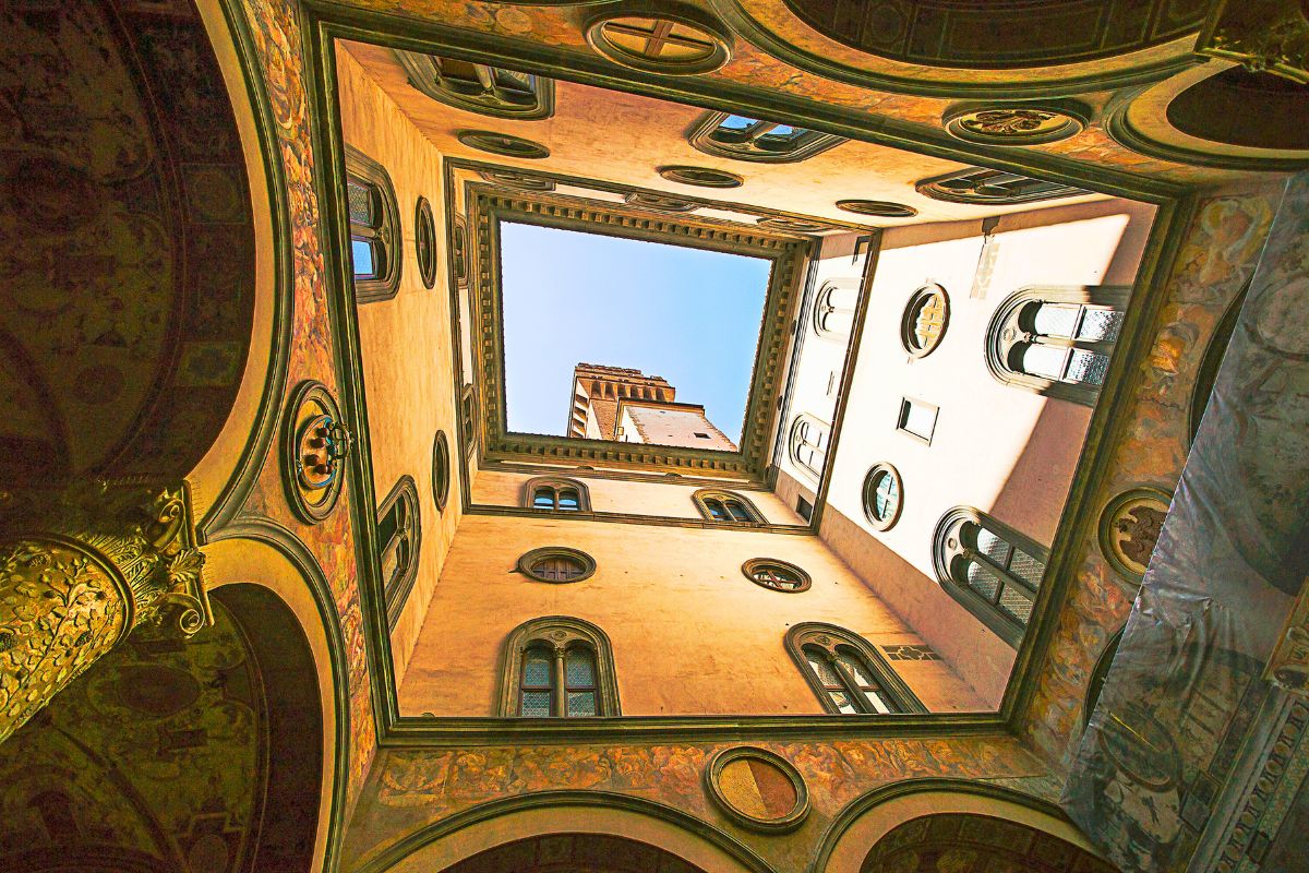 Indre gårdsrom i Uffizi-galleriet i Firenze, sett nedenfra, med renessansearkitektur og åpent himmelrom.