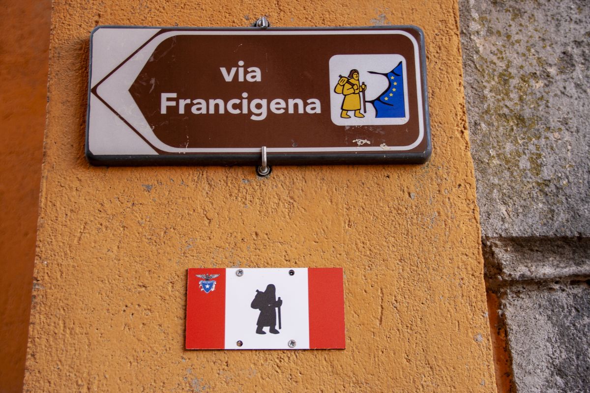 Skilt som markerer Via Francigena, pilegrimsveien gjennom Italia, festet på en mur.