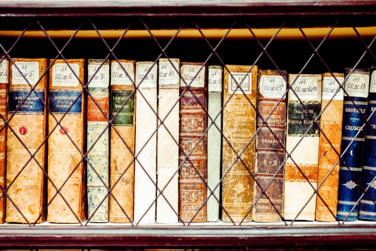 Gamle bøker i et historisk bibliotek, symbol på læring og akademisk kultur.
