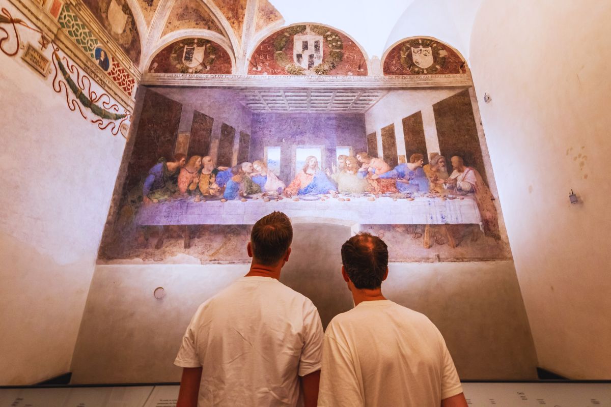 To turister ser på Nattverden av Leonardo da Vinci i Santa Maria delle Grazie i Milano.