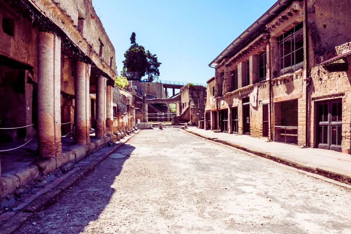 Antikk gate i Herculaneum med søylegang og godt bevarte romerske bygninger på begge sider.