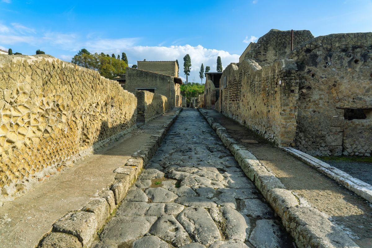 En antikk gate i Herculaneum med steinlagt vei og godt bevarte romerske bygninger.