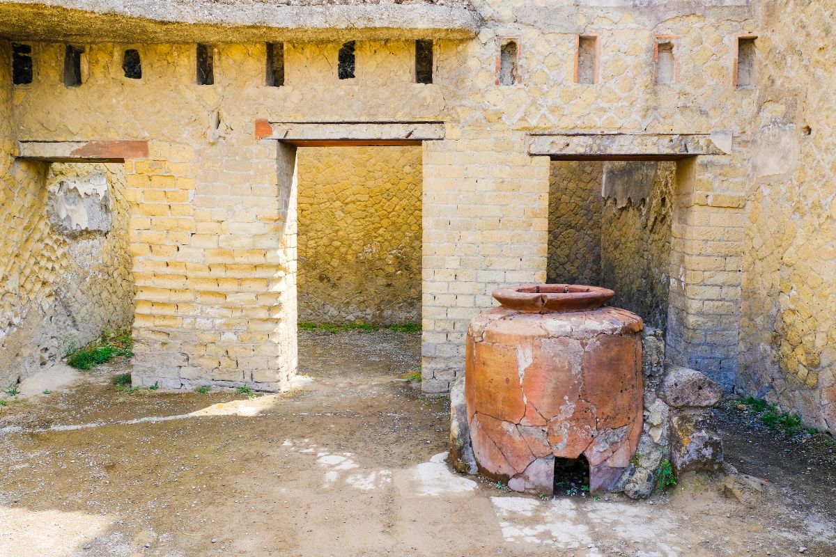 Romersk interiør i Herculaneum med stor krukke og godt bevarte murvegger.