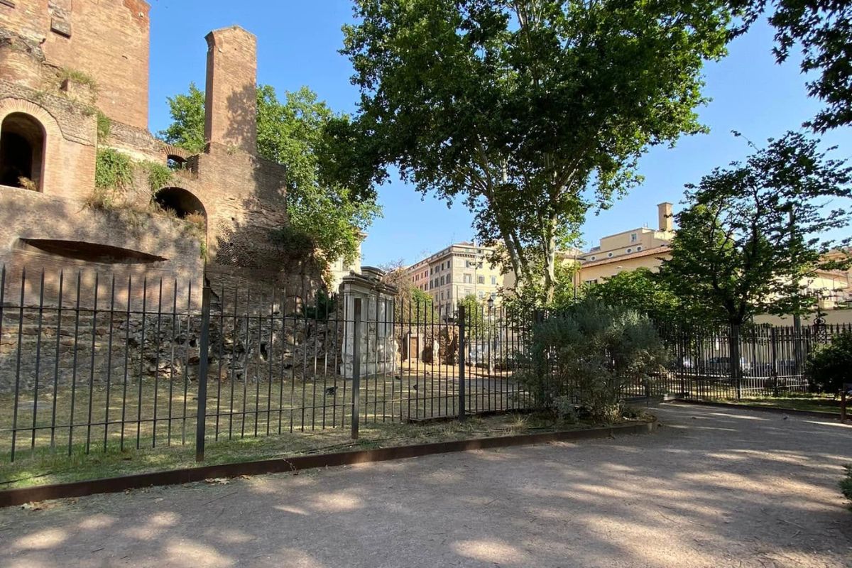Romerske ruiner ved Ninfeo di Mario i Piazza Vittorio Roma med park og bygninger i bakgrunnen.