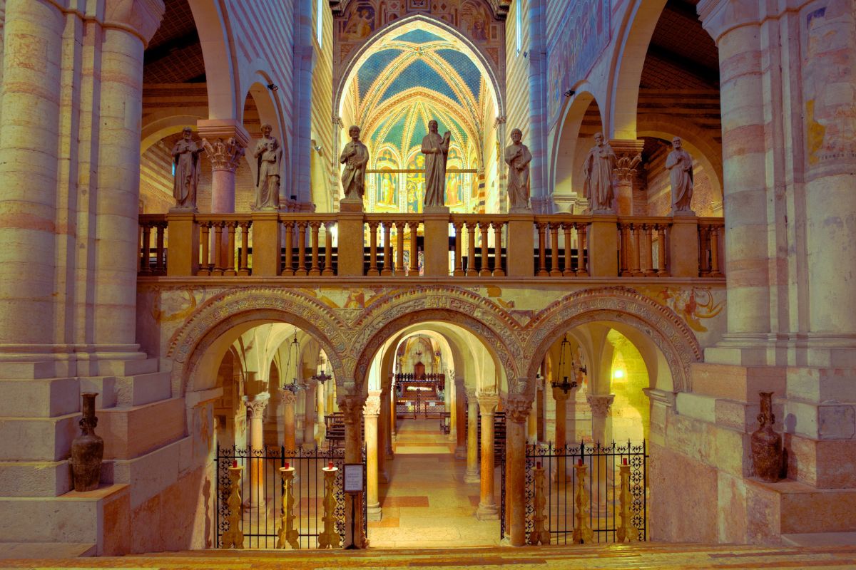 Interiøret i San Zeno-basilikaen i Verona med buer og fresker.