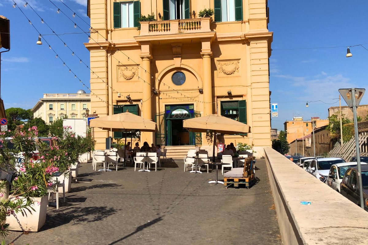 Bar i Roma med utendørs servering på en søndag. Folk sitter ved bordene, nyter kaffe og sosialt samvær i den livlige atmosfæren som preger italienske søndagstradisjoner.