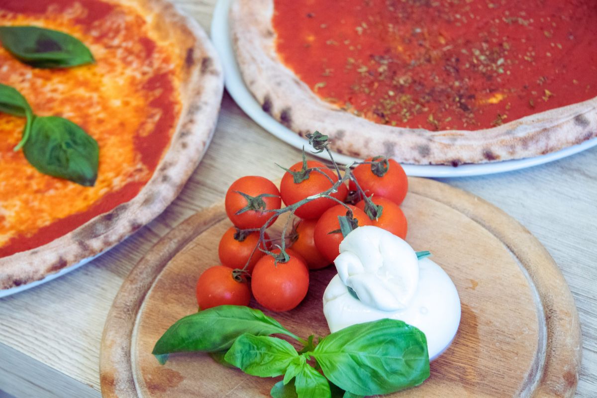 Italienske pizzaingredienser: mozzarella, tomater, basilikum og napolitansk pizza.