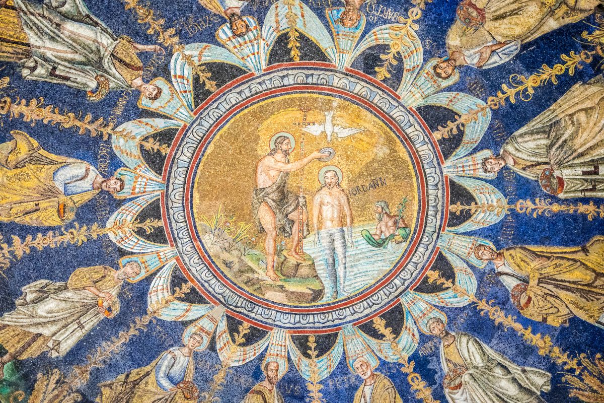Mosaikk i Battistero Neoniano i Ravenna som viser Jesu dåp omgitt av apostlene i sirkel mot blå bakgrunn.