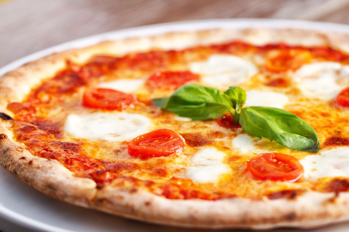 Italiensk pizza margherita med mozzarella, tomatsaus og fersk basilikum.