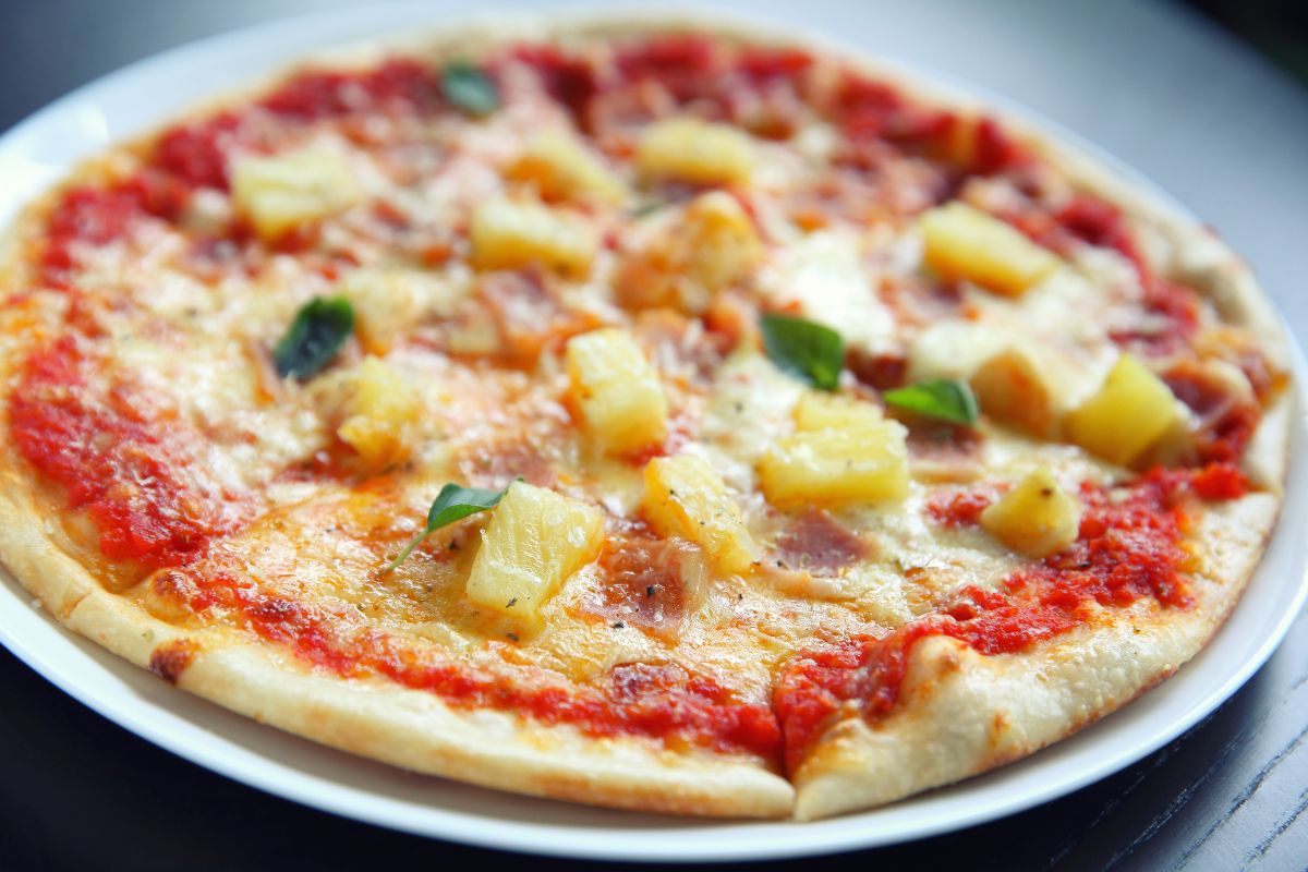 Pizza med ananas, skinke og smeltet ost.