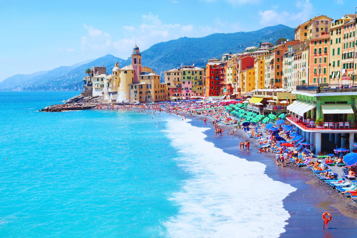 Camogli på den liguriske rivieraen med sine fargerike hus langs strandpromenaden, den livlige stranden og det turkise havet. Den tidligere fiskerlandsbyen regnes som en av de vakreste kystbyene i Liguria.