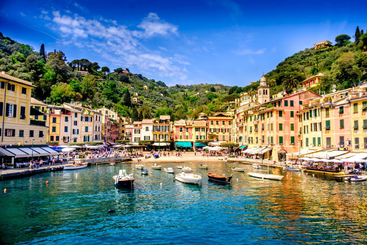 Portofino med sin berømte havn, fargerike hus og små båter som ligger fortøyd i det rolige vannet. Den elegante kystbyen regnes som et symbol på den italienske rivieraen og har i flere tiår tiltrukket seg kjendiser og besøkende fra hele verden.