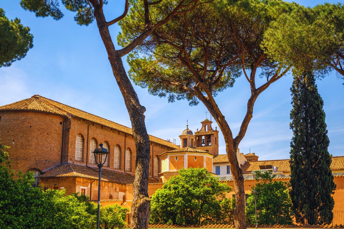 Basilikaen Santa Sabina på Aventinerhøyden i Roma, omgitt av middelhavsfuruer og frodige hager – en av byens vakreste tidligkristne kirker.